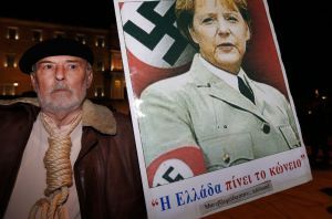 Bu dosya resminde bir adam elinde Almanya Başbakanı Angela Merkel