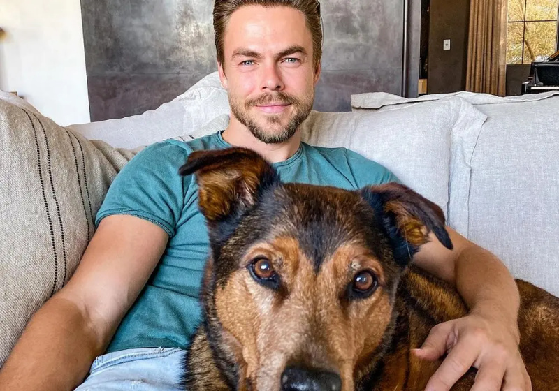 Derek Hough und einer seiner Hunde auf der Couch