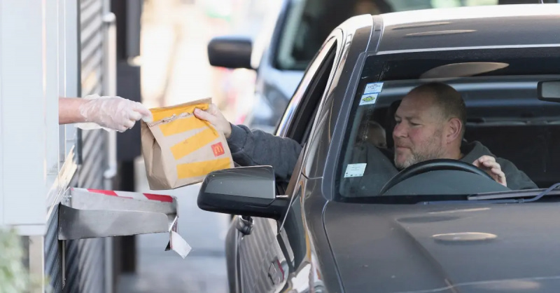 karyawan mcdonalds menyerahkan tas pelanggan di jendela drive-thru