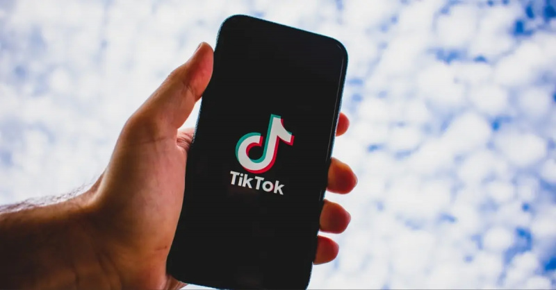 Рука тримає телефон, який завантажує TikTok