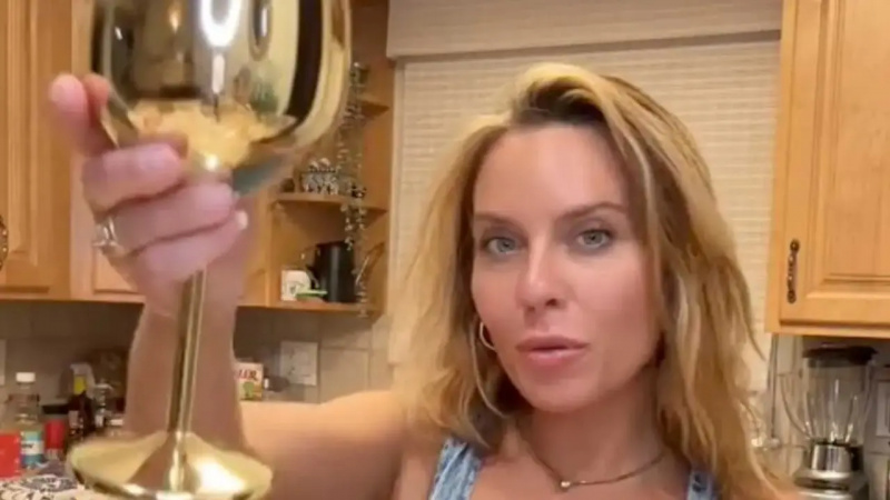 Allyssa hält ein Weinglas in der Hand und diskutiert über das Sein"golf widow"