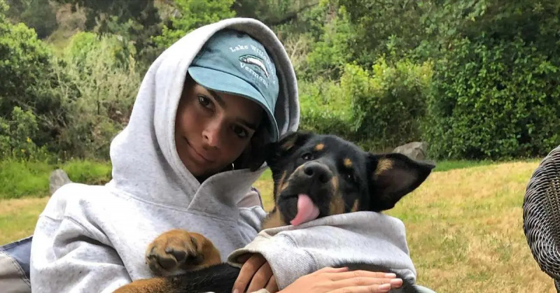 Emily Ratajkowski przytulająca psa w bluzie z kapturem