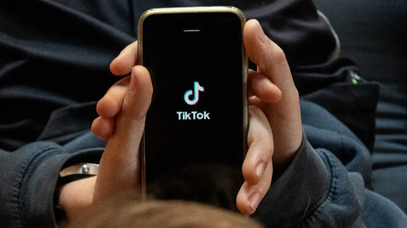 Uma pessoa segurando um smartphone com o logotipo do TikTok na tela