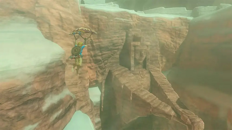 Link usa il suo aliante per viaggiare nel cielo con un bioma roccioso sullo sfondo.
