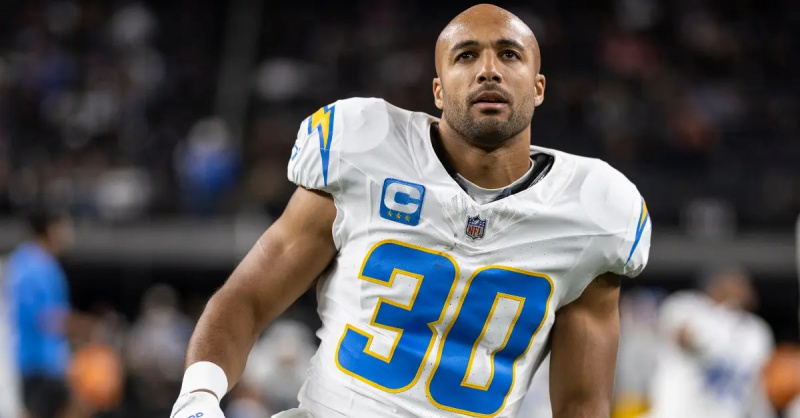 Austin Ekeler, do Los Angeles Chargers, se alonga enquanto se aquece antes de um jogo da NFL em dezembro de 2023