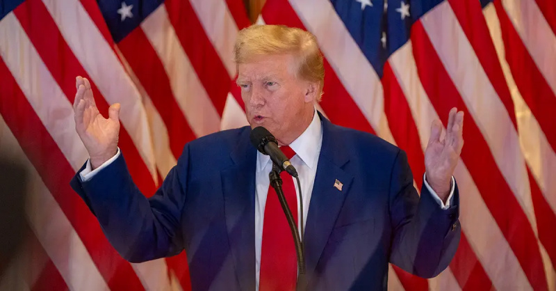 Donald Trump davanti a una bandiera americana