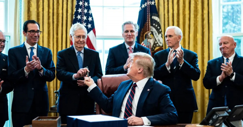 Donaldas Trumpas įteikia rašiklį Mitch McConnell Ovaliame kabinete.