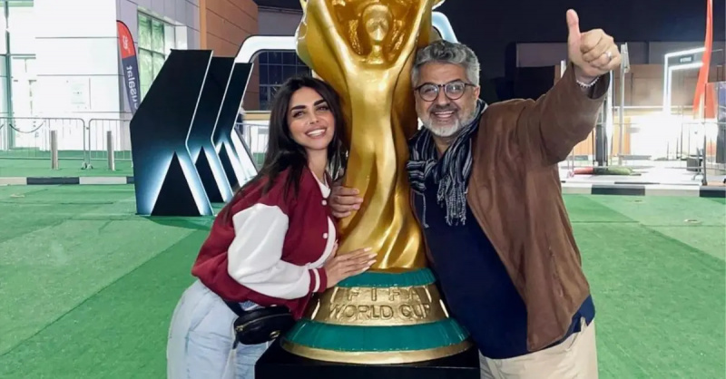 Sara Al Madani dan ayahnya Abdul Wahab Al Madani berpose di kedua sisi patung Piala Dunia FIFA