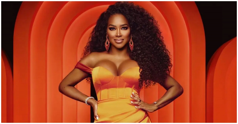   Kenijas Mūrs no'RHOA' holding her hips in an orange dress.