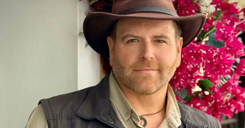 Josh Gates u svom prepoznatljivom šeširu ispred cvijeća