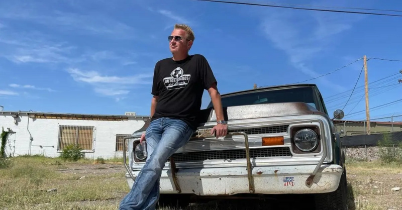 Rob"Rabbit Pitts standing against one of his cars
