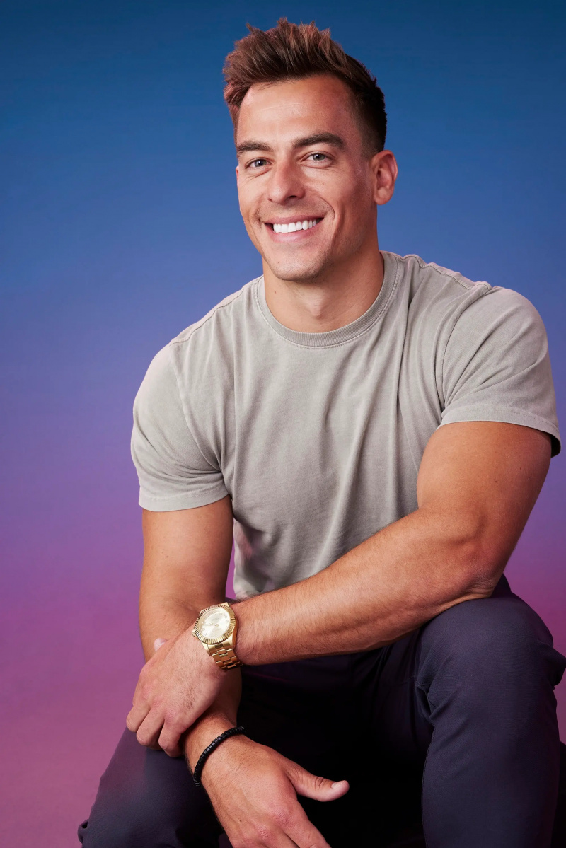 亚伦在蓝紫色渐变背景前摆出正式姿势'The Bachelorette' Season 21 portrait.