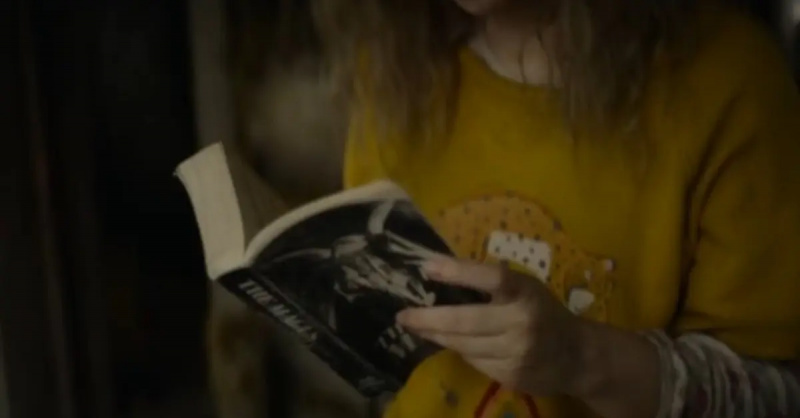   Misty (Sammi Hanratty) læser'The Magus' in the cabin in 'Yellowjackets.'