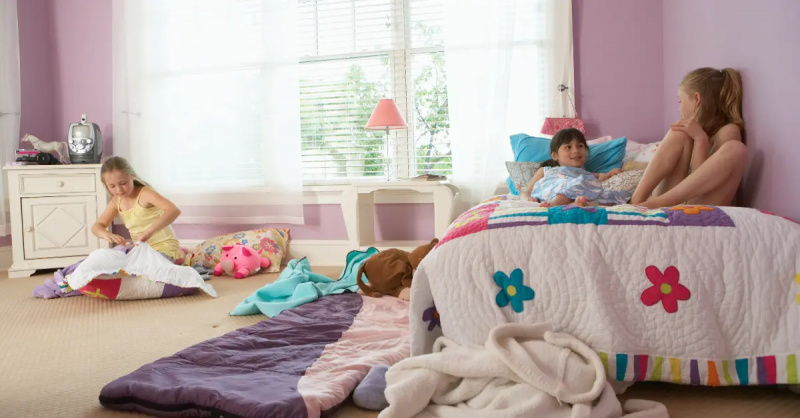 Três meninas sentadas e conversando em um quarto.