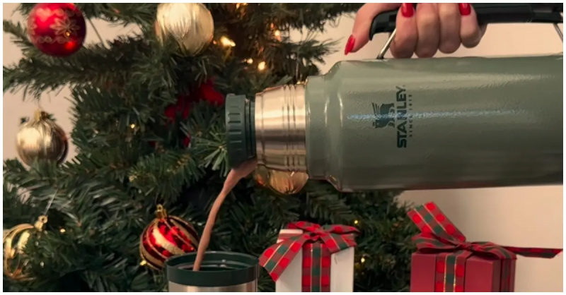 Человек наливает горячий шоколад из стакана Stanley.