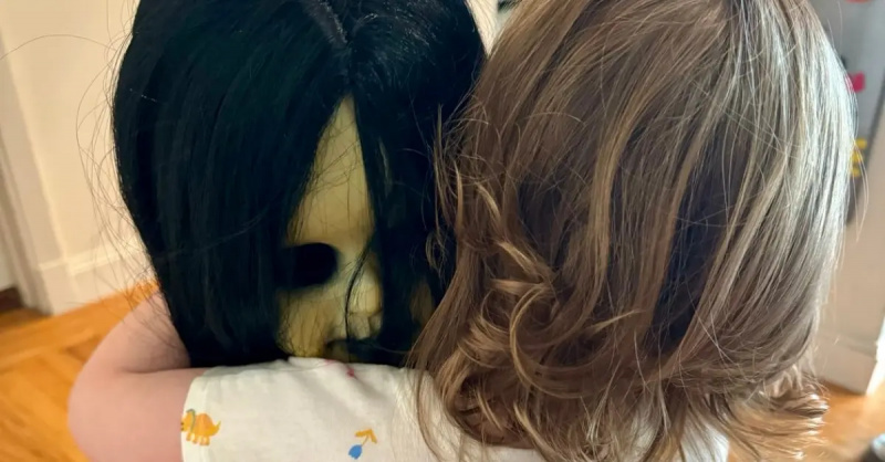 Een klein meisje knuffelt haar enge pop